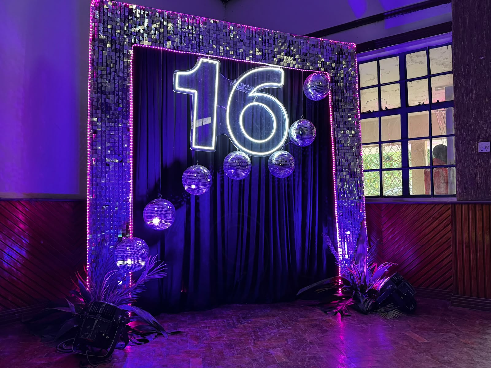 Sweet sixteen backdrop with mirrored sequin frame, glowing neon number and hanging disco balls